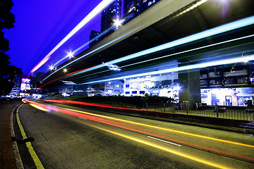 Image showing blurred bus light trails in downtown night-scape 