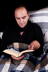 Image showing man lying on the sofa reading a book