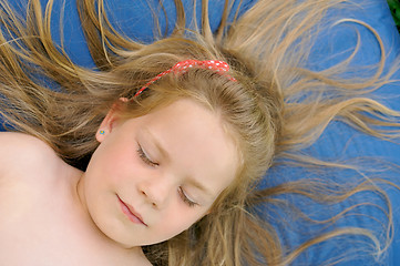 Image showing Little girl sunbathing - laying on mattress