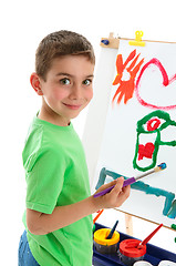 Image showing Young boy artist painting at easel