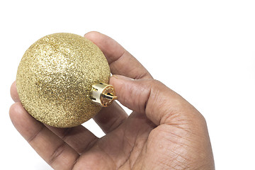 Image showing Hand holding a beautiful golden Christmas ball