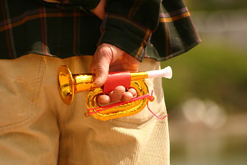 Image showing childs trumpet in a mans hand