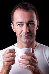 Image showing Portrait of a happy man, drinking a drink