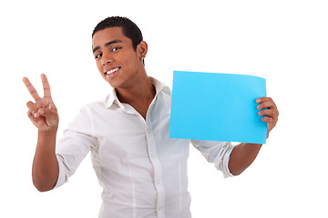 Image showing happy young latino man, with blue card in hand, fingers as sign of victory