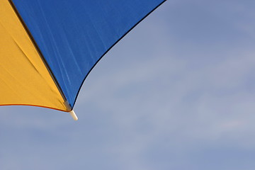 Image showing yellow and blue parasol against a blue sky