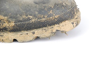 Image showing Muddy rubber boot on white
