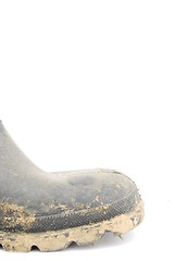 Image showing Muddy rubber boot on white