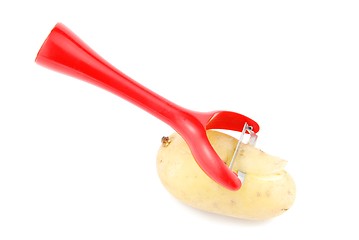 Image showing Peeling a potato with peeler on white