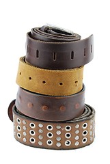 Image showing Stack pile of leather belts on white