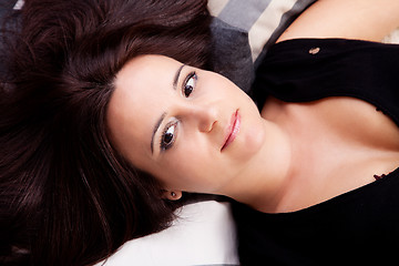 Image showing beautiful and smiling middle-age woman lying