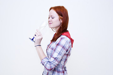 Image showing Redhead young woman is drinking from glass