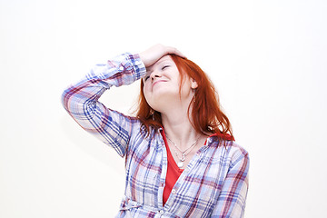 Image showing Redhead young woman holding her hand to the head