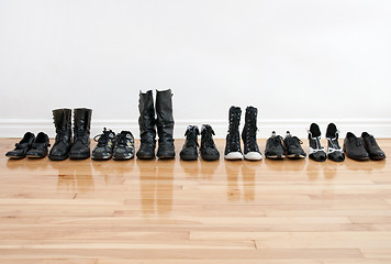 Image showing Row of shoes and boots on a wooden floor