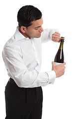 Image showing Sideview man or waiter opening bottle of champagne