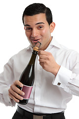 Image showing Happy man opening sparkling wine or champagne