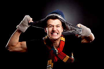 Image showing  man in winter clother pulling his furry hat