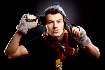 Image showing young man holding a furry hat