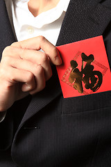 Image showing businessman putting chinese cash gift in his pocket