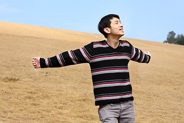 Image showing Carefree man standing in golden grass field being happy enjoying