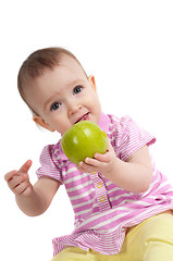 Image showing Baby girl in pink eating apple