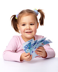 Image showing Little girl with few paper euro banknotes