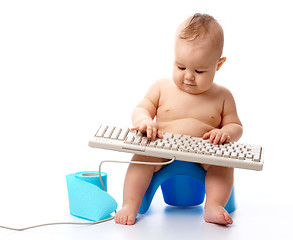 Image showing Little child is typing on keyboard