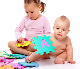 Image showing Little boy and girl are playing with alphabet