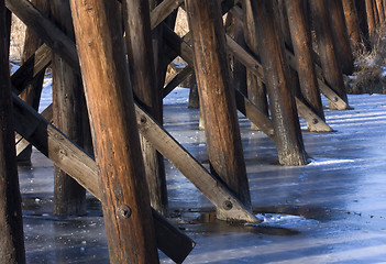 Image showing Wooden railroad trestle across a frozen river