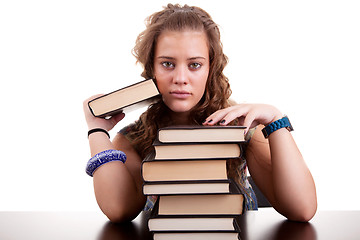 Image showing serious and beautiful girl , with a stack of books