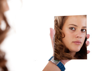 Image showing beautiful blonde young woman looking to a mirror