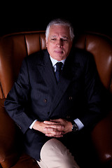 Image showing Pensive mature businessman seated on a chair