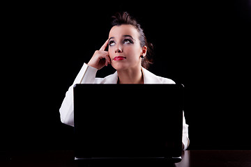 Image showing pretty woman on the computer, thinking looking up