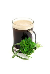 Image showing Dark beer in glass and bouquet of false shamrock with green ribb