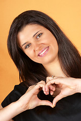 Image showing Young woman making heart with hands