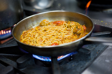 Image showing Spaghetti with meatballs in a pan on a gas oven