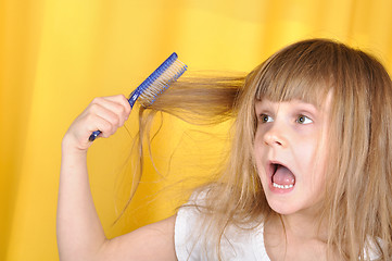 Image showing child having problem with brushing her hair