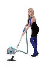 Image showing The girl in blue tights with a vacuum cleaner
