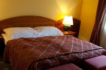 Image showing dressed with a red coverlet bed