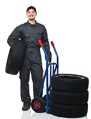 Image showing man with handtruck and tires