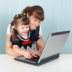 Image showing Mom teaches daughter to use laptop