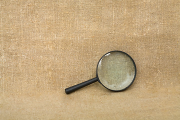 Image showing Old black magnifier on drapery background