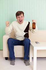 Image showing Football fan sitting on sofa with TV