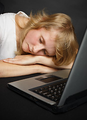 Image showing Woman asleep at table near computer