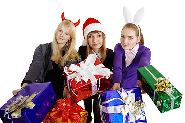 Image showing Three girls hand over New Year's gifts
