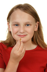 Image showing young girl taking a pill