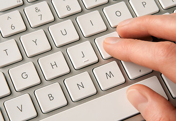 Image showing Hand typing on white computer keyboard