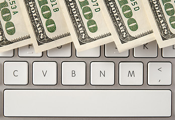 Image showing Hundred dollar bills on computer keyboard with spacebar