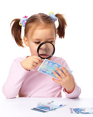 Image showing Girl is looking at euro banknote using magnifier