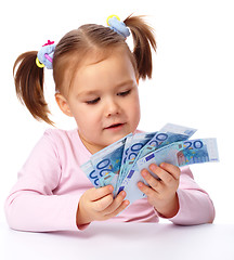 Image showing Little girl with few paper euro banknotes