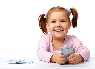 Image showing Little girl with few paper euro banknotes